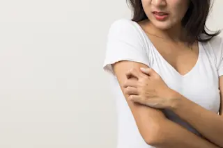 woman scratching an itchy arm