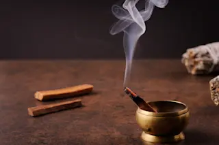 Pala Santo stick burning and smoking on a dark brown background