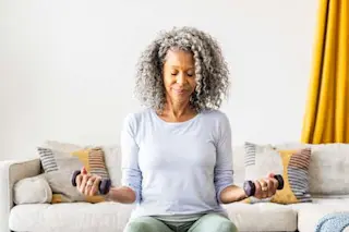older-woman-lifiting-weights-on-exersise-ball