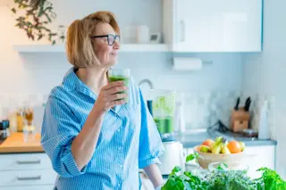 Woman-in-kitchen-drinking-green-smoothie