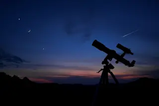 telescope on a hill looking at night sky