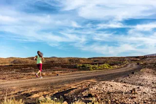 long distance runner trains on remote landscape
