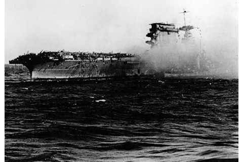 A destroyer alongside USS Lexington (CV-2) as the carrier is abandoned during the afternoon of 8 May 1942. Note crewmen sliding down lines on Lexington’s starboard quarter. Credit: U.S. Navy