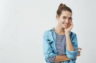 Woman Touching Face - Shutterstock