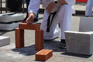 Karate player at a sporting event breaks a brick with his hand