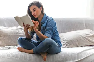 woman reading book - shutterstock
