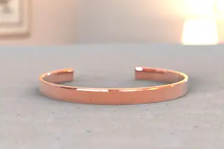 Copper bracelet pain on a table - shutterstock