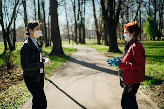 mask women chatting park - shutterstock