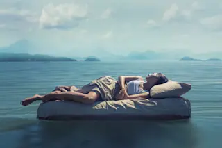 surreal dream bed in an ocean mountains dream interpretation - shutterstock
