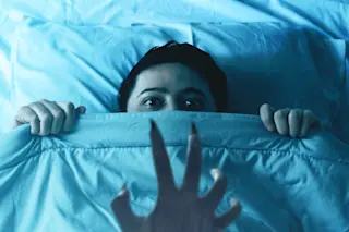 Sleep paralysis demon's claw hovering over someone in bed at night 