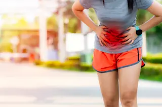 exercise runner holding stomach aches pains - shutterstock