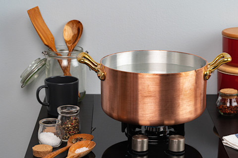 copper pan stovetop cooking - shutterstock 1703690812