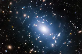 Intracluster light (blue) in the galaxy cluster Abell S1063. One new technique uses intralight, imaged by Hubble, to map and study dark matter. (Credit: NASA, ESA, and M. Montes (University of New South Wales, Sydney, Australia) 