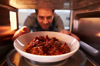 man microwaving dinner - mshutterstock 234673366