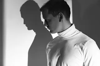 creepy man in a white turtleneck - shutterstock 464439950