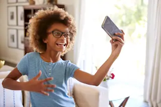Young Girl Child Using Smartphone Social Media Technology - shutterstock 1300416679