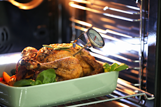 Turkey roasting in the oven with a meat thermometer