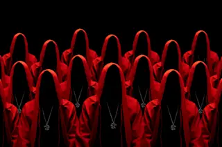 Group of mysterious people in red hooded cloaks representing a cult