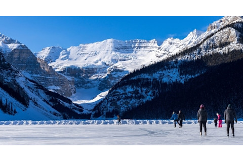 Tourists skating on Lake Louise winter ice skating rink. Banff National Park, Canadian Rockies. Alberta, Canada.