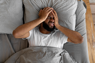 Man with headache in bed