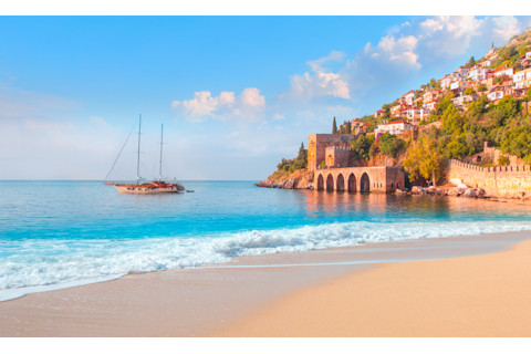 sandy beach and soft turqoise Mediterranean sea wave - Landscape of ancient shipyard near Kizil Kule tower - Alanya peninsula, Turkey