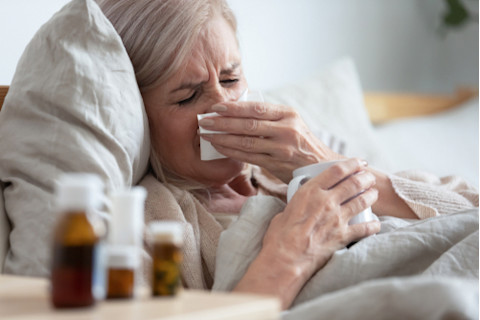 older woman sick with the flu in bed