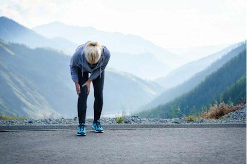 woman running up mountian with knee pain