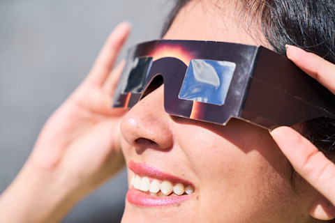 Woman wearing solar eclipse glasses