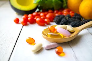 multiple vitamins on a wooden spoon