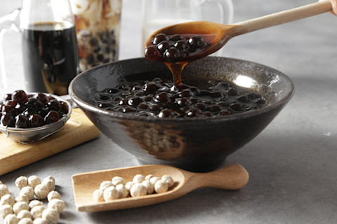 Pearl Bubble Tea close-up on table. Taiwan brown sugar milk tea with boba tapioca pearls