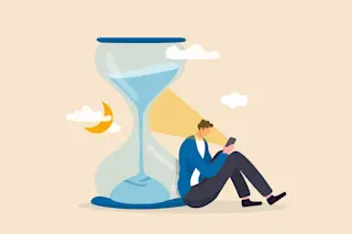 Brain and time: Exhausted man sitting with sandglass using smartphone with bright light on his face.