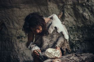 Caveman or Neanderthal making stone tools 