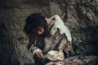 Caveman or Neanderthal making stone tools 