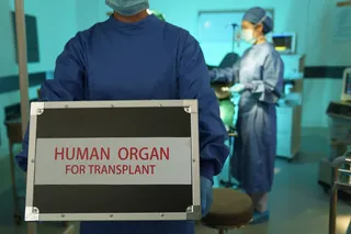 Doctor carrying an organ transplant box