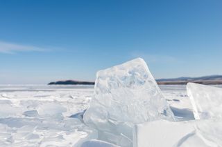 Jagged pieces of ice sticking up from a frozen lake on a sunny day
