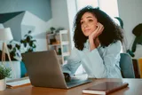 A woman sitting at her desk day dreaming 