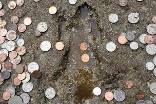 Chicago rat hole impression in side walk cement surrounded by coins Chicago rat hole impression in side walk cement surrounded by coins