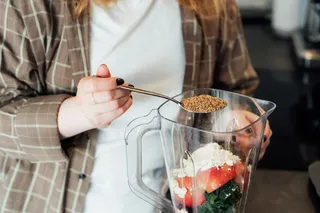 Woman adding fiber to her smoothie Woman adding fiber to her smoothie