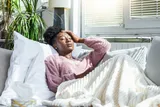Person feeling sick and resting alone on the couch