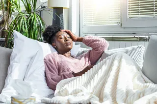 Person feeling sick and resting alone on the couch
