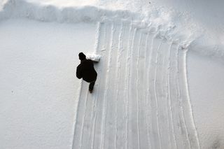 Personal shoveling snow from aerial view point.
