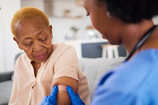 elderly woman getting a vaccine via a nurse elderly woman getting a vaccine via a nurse