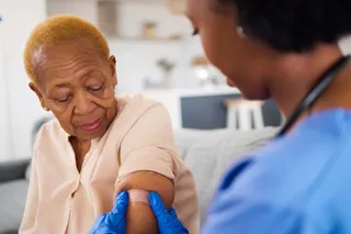 elderly woman getting a vaccine via a nurse 