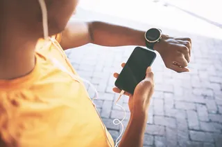 Woman looks at her smart watch to count steps as exercising