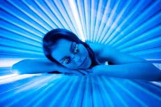 woman laying in a tanning bed woman laying in a tanning bed