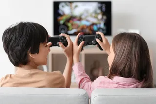 young siblings playing video games 