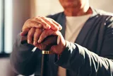 elderly person hands holding a cane