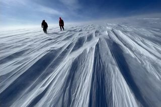 two scientists in winter gear walking on the Prudhoe Dome of Greenland's Ice Sheet. two scientists in winter gear walking on the Prudhoe Dome of Greenland's Ice Sheet.