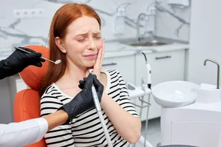 a red headed woman sitting in a dental chair with dental pain a red headed woman sitting in a dental chair with dental pain