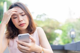 woman stressed out looking at her phone